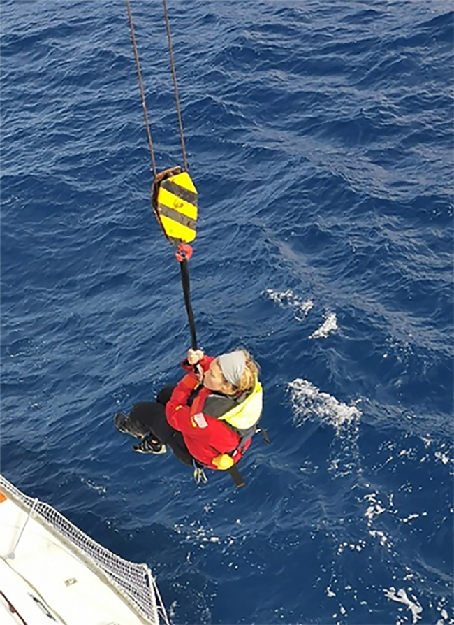 Handout picture released by the Chilean Navy's Maritime Rescue Coordination Centre (MRCC CHILE) showing the moment in which British yachtswoman Susie Goodall is being rescued by the Hong Kong-flagged vessel Tian Fu in Chilean jurisdiction waters in the Southern Ocean, after coordination between the MRCC, agencies and vessels, on December 7, 2018 a day after her yacht DHL Starlight was dismasted while on the Golden Globe Race. The 40,000 tonne Tian Fu with Goodall on board, is expected to dock in Punta Arenas, in southern Chile, on December 12. [Photo: AFP/Chile's Maritime Rescue Coordination Centre]