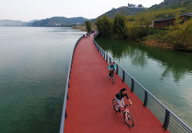 Residents ride bicycles on a bike path along the Liujiang River in Liuzhou, in south China' Guangxi Zhuang Autonomous Region. [Photo provided to China Plus]