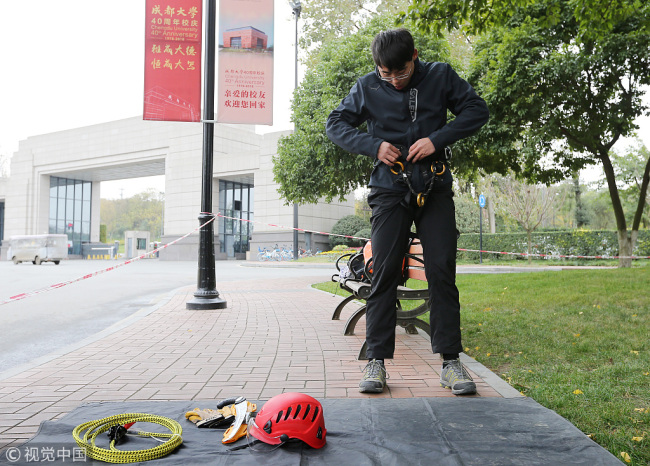 A student prepares the safety equipment before practicing tree climbing in a class at Chengdu University on Friday, December 6, 2018. [Photo: VCG]