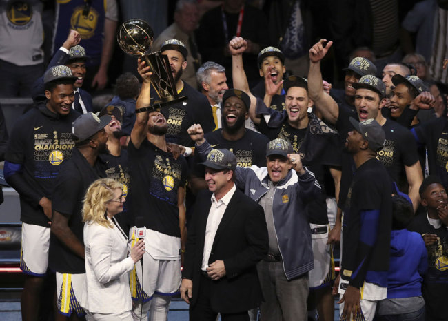 In this Friday, June 8, 2018, file photo, the Golden State Warriors celebrate after defeating the Cleveland Cavaliers 108-85 in Game 4 of basketball's NBA Finals to win the NBA championship, in Cleveland. The three-time NBA champion Golden State Warriors are the fourth team to be honored as Sports Illustrated’s Sportsperson of the Year, the magazine announced Monday, Dec. 10, 2018. [File photo: AP/Carlos Osorio]
