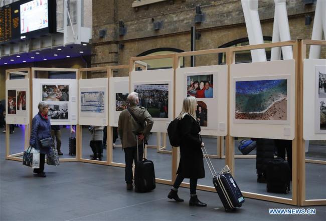 Passengers view a photography exhibition at London's Kings Cross Station in London, Britain, Dec. 10, 2018. [Photo: Xinhua]