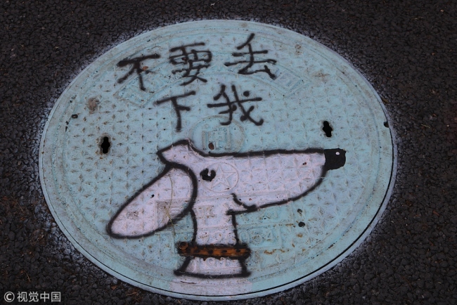 “汪星人”呼唤大家文明养犬 Beijing manhole art promotes proper dog ownership