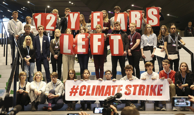 Polish teenagers stage a protest in the U.N. climate conference venue on the last days of talks to urge negotiators from almost 200 countries to reach an agreement on ways of keeping global warming in check in Katowice, Poland, Friday, Dec. 14, 2018. [Photo: AP/Czarek Sokolowski]