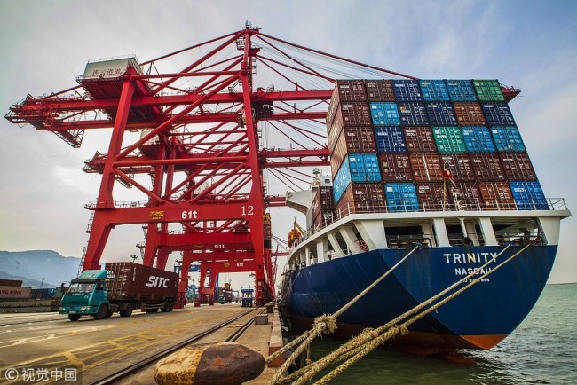 A cargo ship unloads goods at a container terminal of Lianyungang Port, Jiangsu province. [File Photo: VCG]