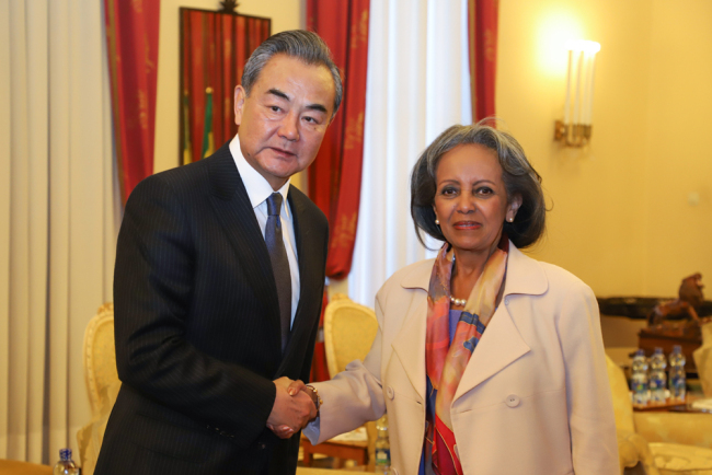 China's Foreign Minister Wang Yi (L) and Ethiopia's President Sahle-Work Zewde (R) shake hands ahead of a meeting at the national palace in Addis Ababa, on January 3, 2019 during Wang's official four-nation Africa tour. [AFP/Michael Tewelde]