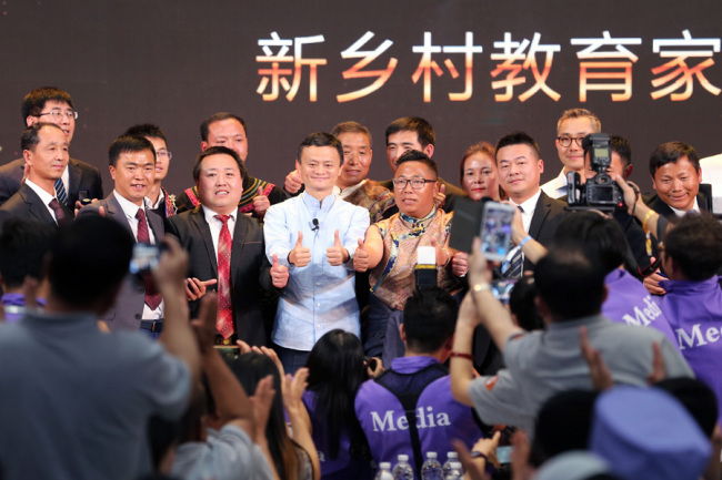Jack Ma is surrounded(围绕 wéirào) by the award-winning rural headmasters(校长 xiàozhǎng) in Sanya, Hainan province, January 13, 2019. [Photo provided to chinadaily.com.cn]