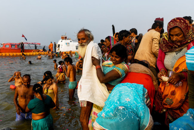Indian devotees take a dip on the banks of the Triveni Sangam, the confluence of the Ganges, Yamuna and mythical Saraswati rivers, as people gather for the Kumbh Mela festival in Allahabad on January 14, 2019. [Photo: AFP/Chandan Khanna]