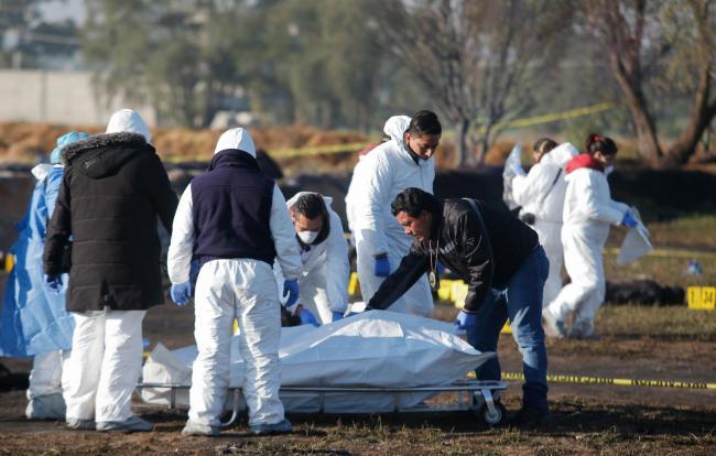 Forensic experts working in the area an oil pipeline explosion in Tlahuelilpan, Hidalgo state, Mexico, Saturday, Jan. 19, 2019. A massive fireball that engulfed people scooping up fuel spilling from a pipeline ruptured by thieves in central Mexico killed dozens of people and badly burned many more. [Photo: AP/Claudio Cruz]