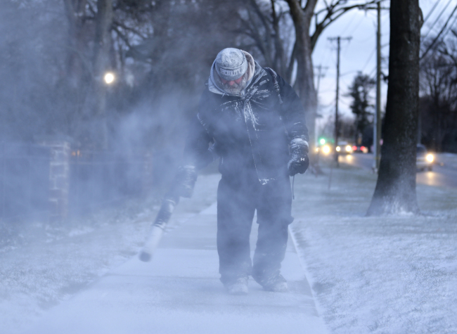 James Dusenbery blows a dusting snow off the sidewalk in Englewood, N.J., Wednesday, Jan. 30, 2019. [Photo: AP/Seth Wenig]
