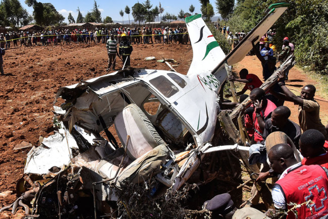 Rescuers work to move the wreckage of a Cessna 206 light aircraft that crashed at Londiani in Kericho district, some 220 km northwest of Nairobi, on February 13, 2019, killing all five people onboard. [Photo: AFP/Suleiman Mbatiah]