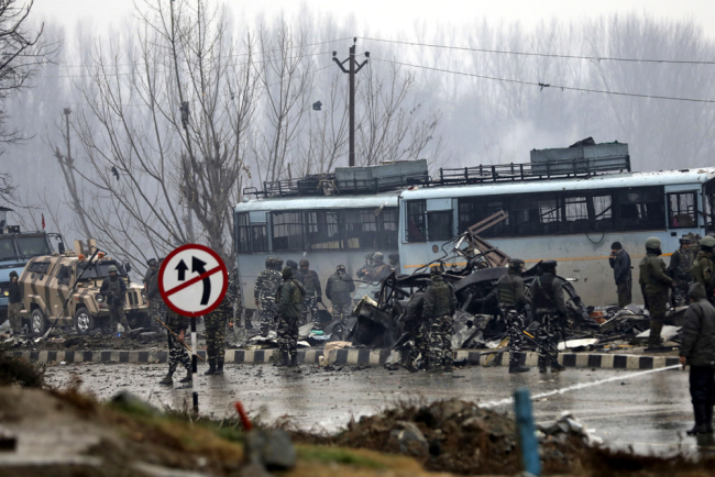 Indian paramilitary soldiers stand by the wreckage of a bus after an explosion in Pampore, Indian-controlled Kashmir, Feb. 14, 2019. [Photo: AP/Umer Asif]