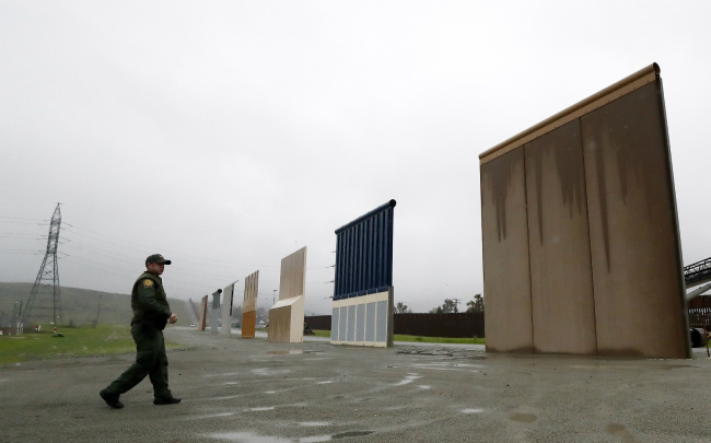 Border Patrol agent Vincent Pirro walks towards prototypes for a border wall Tuesday, Feb. 5, 2019, in San Diego. President Donald Trump is expected to speak about funding for a wall along the U.S.-Mexico border during his State of the Union address Tuesday. [Photo: AP/Gregory Bull]