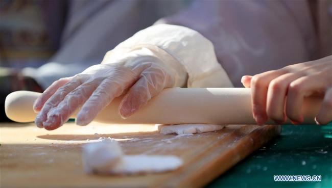 A staff member demonstrates dumpling-making during a celebration of Chinese Lunar New Year at the Original Farmers Market in Los Angeles, the United States, Feb. 17, 2019. [Photo: Xinhua]
