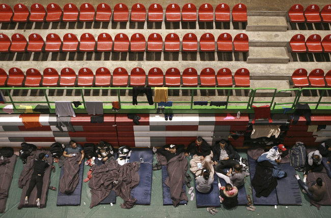 Migrants from Central America, Africa and the Caribbean, who are awaiting their turns to request asylum in the U.S., pass the time inside a shelter in Bachilleres gymnasium in Ciudad Juarez, Mexico, Tuesday, Feb. 19, 2019. Hundreds of migrants, some of whom arrived from the recently closed shelter in Piedras Negras on the Mexico-U.S. border, are camped out in the gym waiting their chance to submit their asylum request at the El Paso port of entry. [Photo: AP]