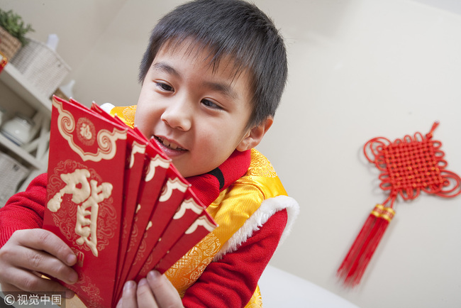 Chinese children holding Lunar New Year's Hongbao, or lucky money. It is a Lunar New Year tradition in China to give children money in red envelopes to wish them a safe and peaceful year. [File Photo: VCG]