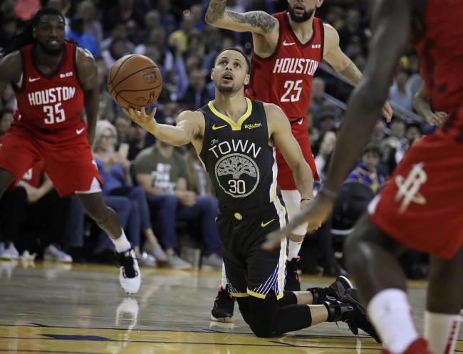 Golden State Warriors' Stephen Curry (30) shoots from his knees in the second half of an NBA basketball game against the Houston Rockets Saturday, Feb. 23, 2019, in Oakland, Calif. [Photo: AP/Ben Margot]