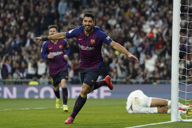 Barcelona forward Luis Suarez celebrates after Real defender Raphael Varane scores an own goal during the Copa del Rey semifinal second leg soccer match between Real Madrid and FC Barcelona at the Bernabeu stadium in Madrid, Spain, Wednesday Feb. 27, 2019. [Photo: AP]