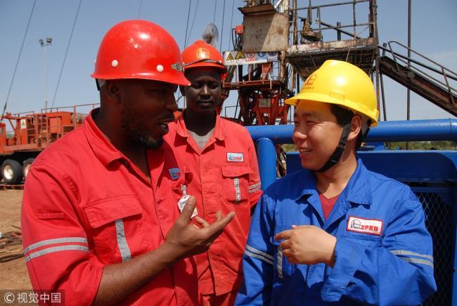 Chinese and Sudanese employees of China's Sinopec Group chat with each other in Sudan. [File photo: VCG]