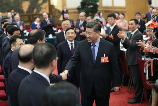 President Xi Jinping shakes hands with his fellow deputies from Fujian Province at the second session of the 13th National People's Congress in Beijing on March 10, 2019. [Photo: Xinhua]