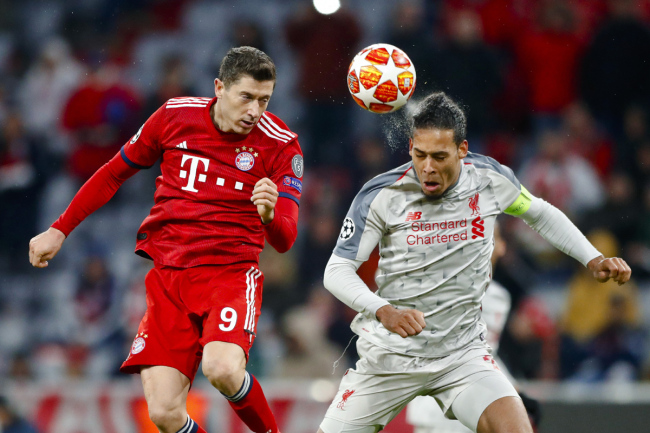 Bayern forward Robert Lewandowski, left, jumps for a header with Liverpool defender Virgil Van Dijk during the Champions League round of 16 second leg soccer match between Bayern Munich and Liverpool in Munich, Germany, Wednesday, March 13, 2019. [Photo: AP]