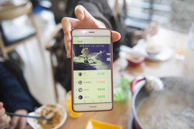 A student at Zhejiang Gongshang University presents the number of daily steps recorded in WeChat at an on-campus restaurant to get a discount on their bill on Wednesday, March 13, 2019. [Photo: IC]
