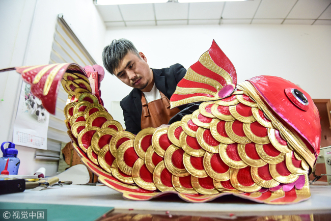 Zhang Renbing making a Koi fish bag(锦鲤包 jǐnlǐ  bāo). Koi is well known in China as a symbol of luck. [Photo: VCG]