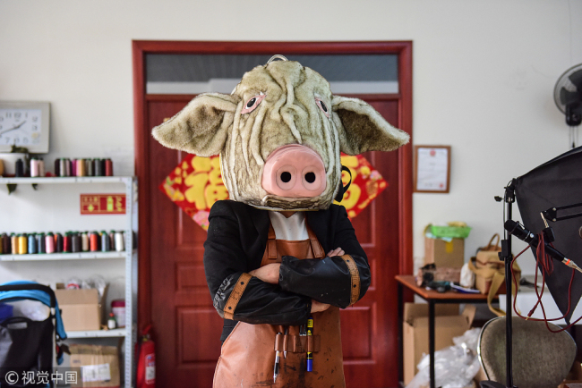 Zhang Renbing with his "pig head bag" which can be carried not only on the body, but also on the head. [Photo: VCG]