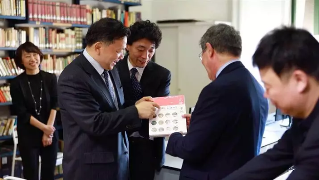 Shen Haixiong, the president of China Media Group, shows the gift to a teacher at the school. [Photo: CCTV]
