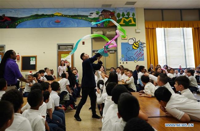 Chen Lihui (C) from Zhangzhou city in southeast China's Fujian province performs Fujian Puppetry at Paint Branch Elementary School in the Prince George's County, Maryland, the United States, March 20, 2019. [Photo: Xinhua]