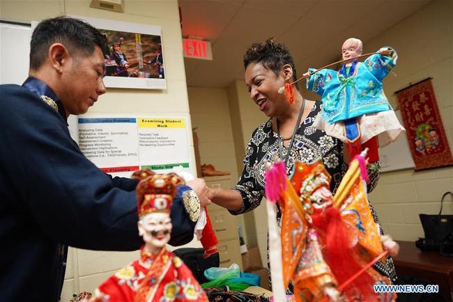 Tricia Hairston (R), principal of Paint Branch Elementary School, tries to perform Fujian Puppetry at Paint Branch Elementary School in the Prince George's County, Maryland, the United States, March 20, 2019. [Photo: Xinhua]