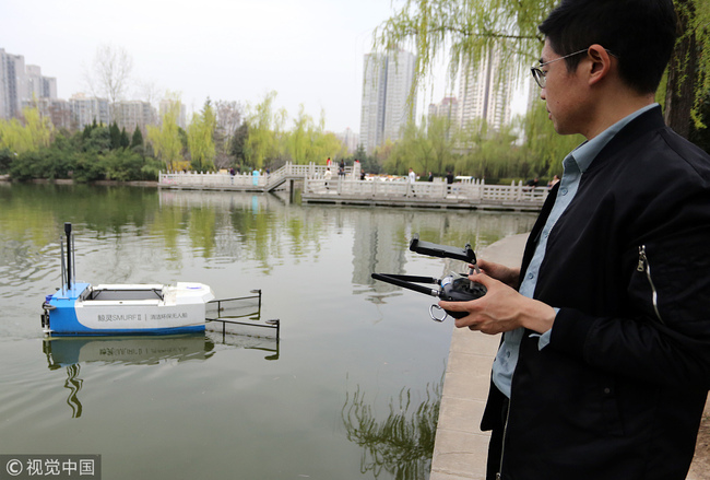 An operator controls the boat as it cleans water in a park in Xi'an on March 19, 2019. [Photo: VCG]