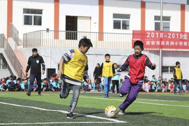 Students in an elementary school in Huaian, Jiangsu province, play in a football match on March 12, 2019. [Photo: VCG]