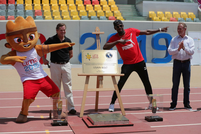 Jamaican eight-time Olympic sprinting champion Usain Bolt (2-R) poses with the mascot of Pan American Games during a ceremony at the Videna Stadium in Lima, Peru, April 3, 2019. [Photo: IC]