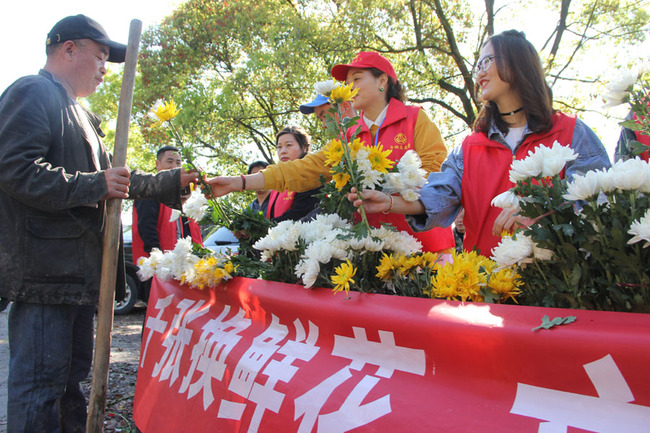 Volunteers offer free flowers for local residents for exchange of joss paper to promote civilized worship practice on Tomb Sweeping Day on Apr 5, 2019 in Wenling, Zhelinag Province. [Photo: IC]