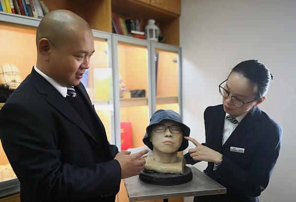 Wang Gang(L) is working on the 3D printing model.[Photo: www.thepaper.cn]