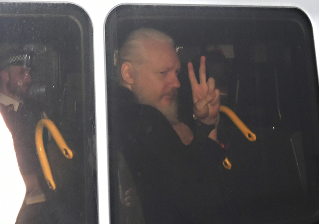 Julian Assange gestures as he arrives at Westminster Magistrates' Court in London, after the WikiLeaks founder was arrested by officers from the Metropolitan Police and taken into custody Thursday April 11, 2019. Police in London arrested WikiLeaks founder Assange at the Ecuadorean embassy Thursday, April 11, 2019 for failing to surrender to the court in 2012, shortly after the South American nation revoked his asylum .[Photo: PA via AP/Victoria Jones]