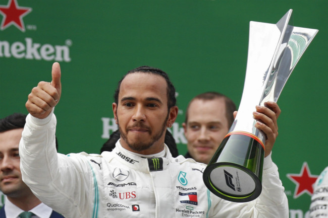 Mercedes driver Lewis Hamilton of Britain celebrates with the trophy after winning the Chinese Formula One Grand Prix at the Shanghai International Circuit in Shanghai on Sunday, April 14, 2019. [Photo: AP]
