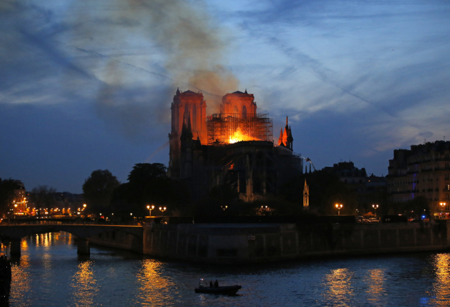 Firefighters tackle the blaze as flames and smoke rise from Notre Dame cathedral as it burns in Paris, Monday, April 15, 2019. Massive plumes of yellow brown smoke is filling the air above Notre Dame Cathedral and ash is falling on tourists and others around the island that marks the center of Paris. [Photo: AFP]