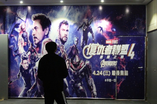 A man stands in front of the poster of “Avengers: Endgame” in a cinema. [Photo: IC]