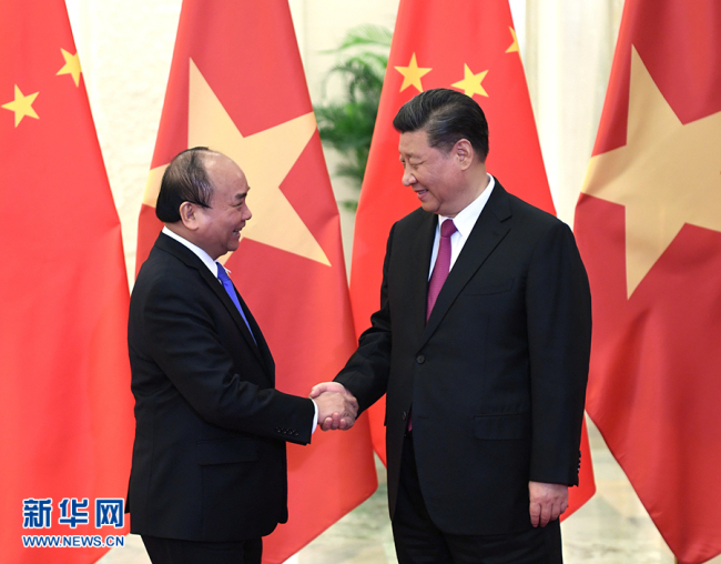 Chinese President Xi Jinping (R) shakes hands with Vietnamese Prime Minister Nguyen Xuan Phuc on Thursday, April 25, at the Great Hall of the People, in Beijing. [Photo: Xinhua]