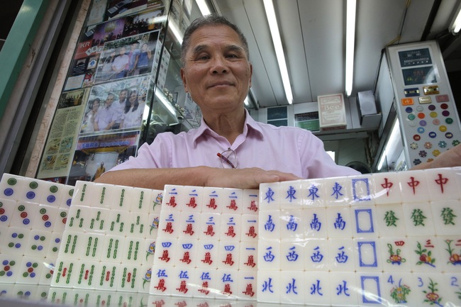 In this April 18, 2019, photo, Cheung Shun-king, 65-year-old mahjong game tile maker, poses with his tiles in his shop in Kowloon's old neighborhood of Hong Kong. [Photo: AP]