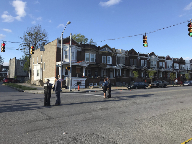 Authorities stand at Edmondson and Whitmore after multiple people were shot, Sunday, April 28, 2019, in Baltimore. [Photo: AP]