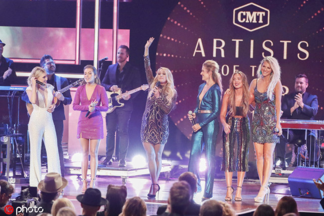 From left, Maddie Marlow and Tae Dye of Maddie & Tae, Carrie Underwood, and Hannah Mulholland, Naomi Cooke, and Jennifer Wayne of Runaway June, at the 2018 CMT Artists of the Year show in Nashville, Tenn. on October 17, 2018. [Photo:IC]