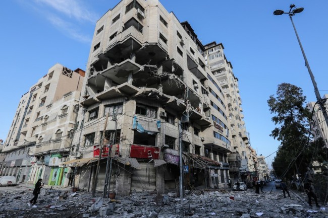 A damage building stands on a debris-strewn street in Gaza City on May 5, 2019, that was hit during Israeli air strikes on the Palestinian enclave. [Photo: AFP/Mahmud Hams] 
