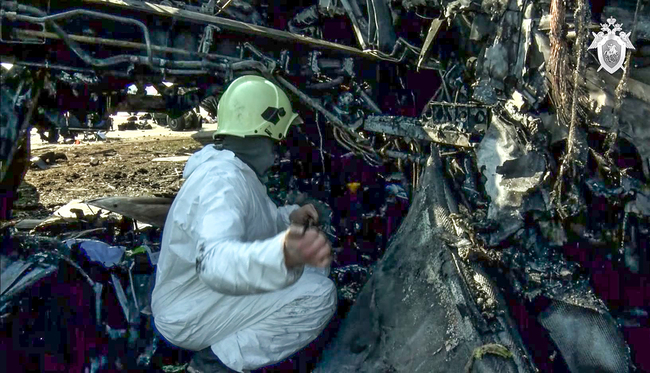 This handout picture taken and realeased on May 6, 2019 by the Investigative Committee of Russia shows an investigator as he works at a site of a fire of a Russian-made Superjet-100 at Sheremetyevo airport outside Moscow.  [Photo: AFP]