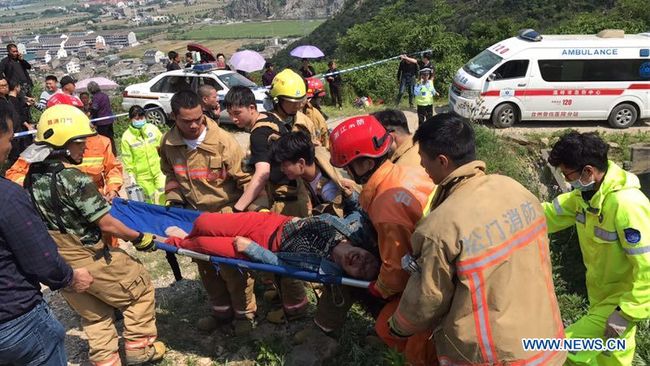 Rescuers carry an injured person at the site of a traffic accident in Wenling, east China's Zhejiang Province, May 12, 2019. Twelve people were killed and 11 others injured after a farm vehicle overturned Sunday in eastern China's Zhejiang Province, local authorities said. The rollover occurred halfway up a mountain in Songmen town, Wenling city, the local public security bureau said. [Photo: Xinhua]