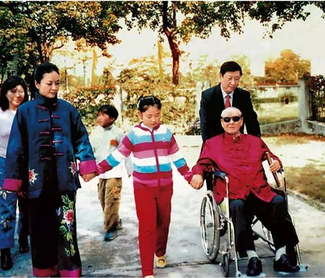 Undated photo showing Xi Jinping taking his father in a wheelchair for a walk along with his wife Peng Liyuan and their daughter. [Photo: China Plus]
