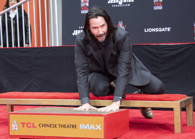 Actor Keanu Reeves places his hands in cement during his handprint ceremony at the TCL Chinese Theatre IMAX forecourt on May 14, 2019 in Hollywood, California. [Photo: AFP/Valerie Macon]