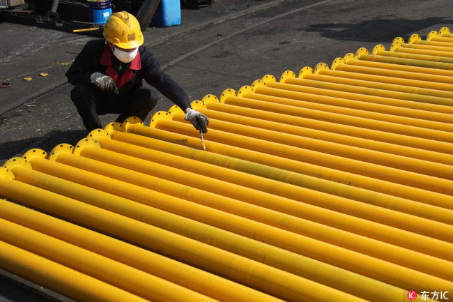 A worker paints equipment at a factory in Huaibei City, Anhui Province. [File Photo: IC]