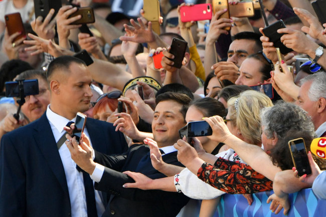 Ukrainian president-elect Volodymyr Zelensky takes selfie pictures with supporters prior to his inauguration ceremony at the parliament in Kiev on May 20, 2019. [Photo: AFP/Sergei Supinsky]